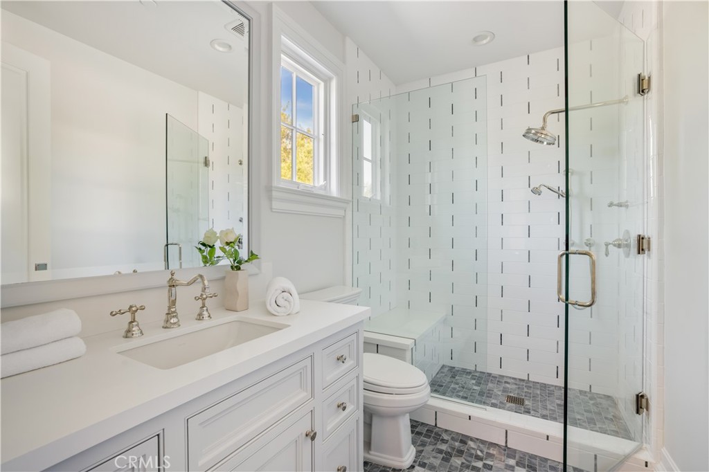 24200 Hidden Ridge Road Hidden Hills, CA 91302 - Photo 36 of 61 a bathroom with a granite countertop sink a toilet and shower