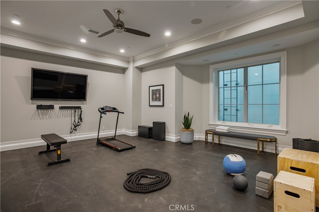 24200 Hidden Ridge Road Hidden Hills, CA 91302 - Photo 41 of 61 a living room with furniture a flat screen tv and gym equipment