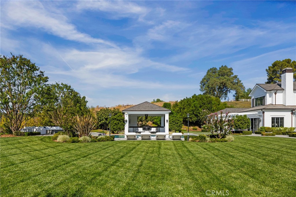 24200 Hidden Ridge Road Hidden Hills, CA 91302 - Photo 57 of 61 a view of house in front of a big yard with potted plants and large trees