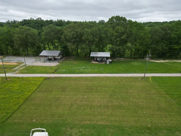 a view of a green field with wooden fence