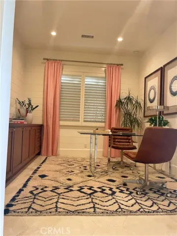 a view of an empty room and kitchen with wooden floor