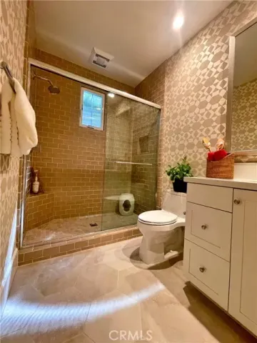 a bathroom with a sink a toilet and shower
