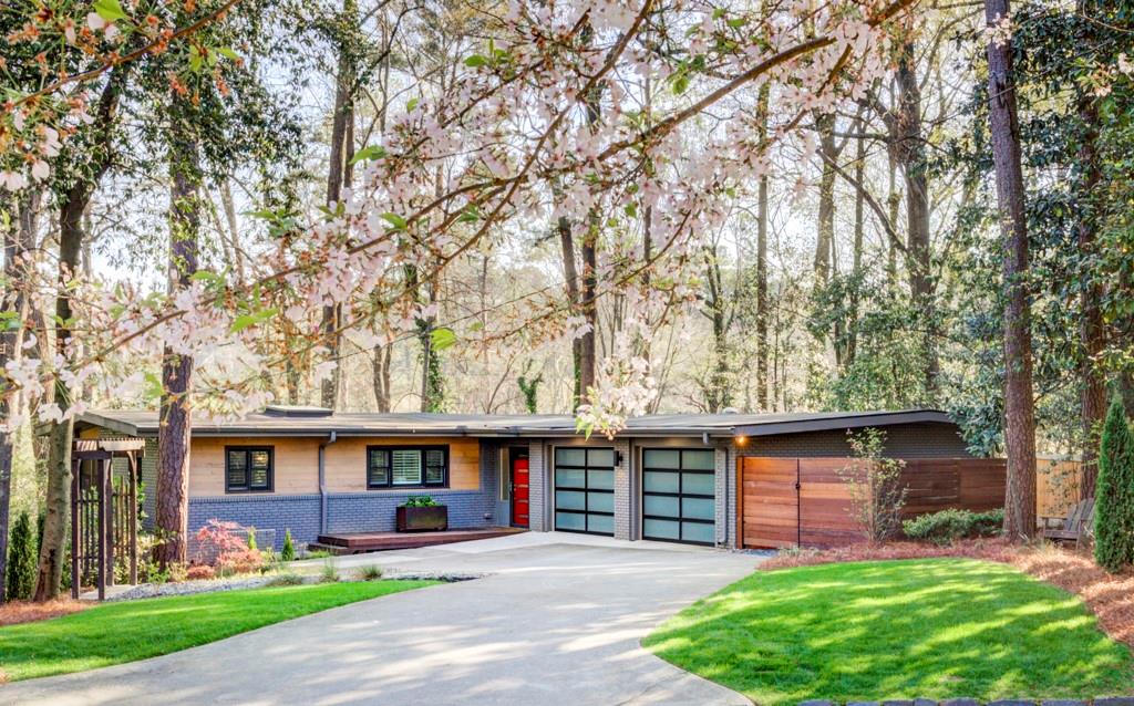 1921 Walthall Drive Northwest Atlanta, GA 30318 - Photo 1 of 45 a front view of a house with a garden and trees