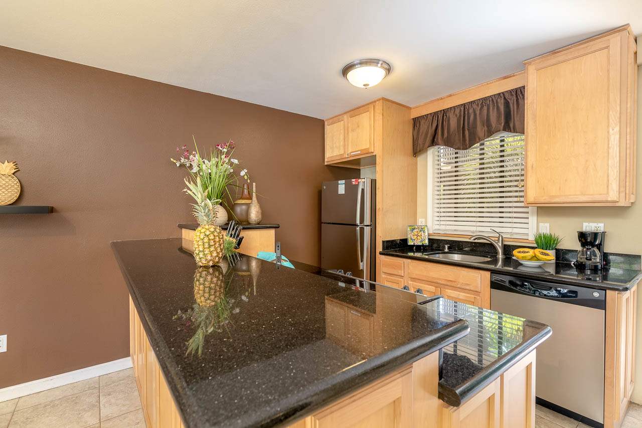 2219 South Kihei Road, Unit B216 Kihei, HI 96753 - Photo 2 of 29 a kitchen with granite countertop a sink a counter top space and cabinets
