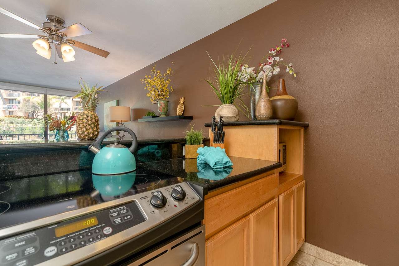 2219 South Kihei Road, Unit B216 Kihei, HI 96753 - Photo 4 of 29 a kitchen with stainless steel appliances granite countertop a stove a sink and a dining table