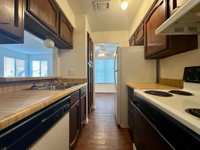 a kitchen with stainless steel appliances granite countertop a stove a sink and a refrigerator