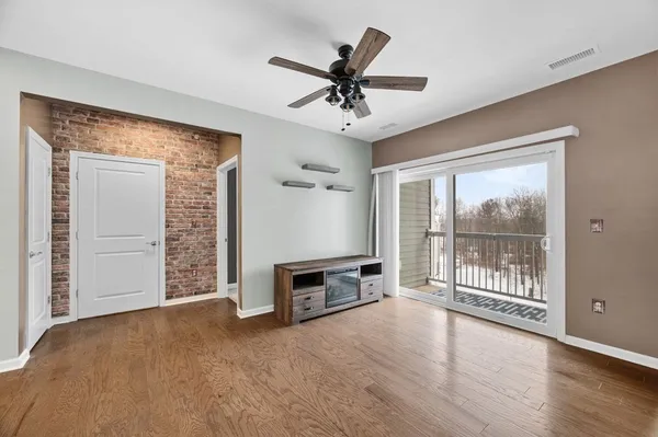 a view of kitchen with stainless steel appliances refrigerator microwave and dining table