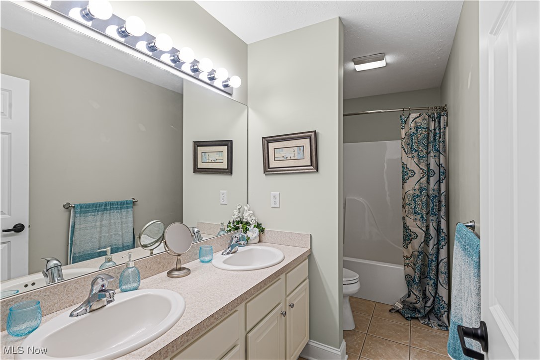 2251 Timber Ridge Trail Streetsboro, OH 44241 - Photo 35 of 48 Full bathroom featuring shower / tub combo, tile patterned flooring, a textured ceiling, toilet, and dual bowl vanity