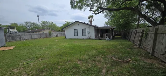 a view of a house with a yard and fence