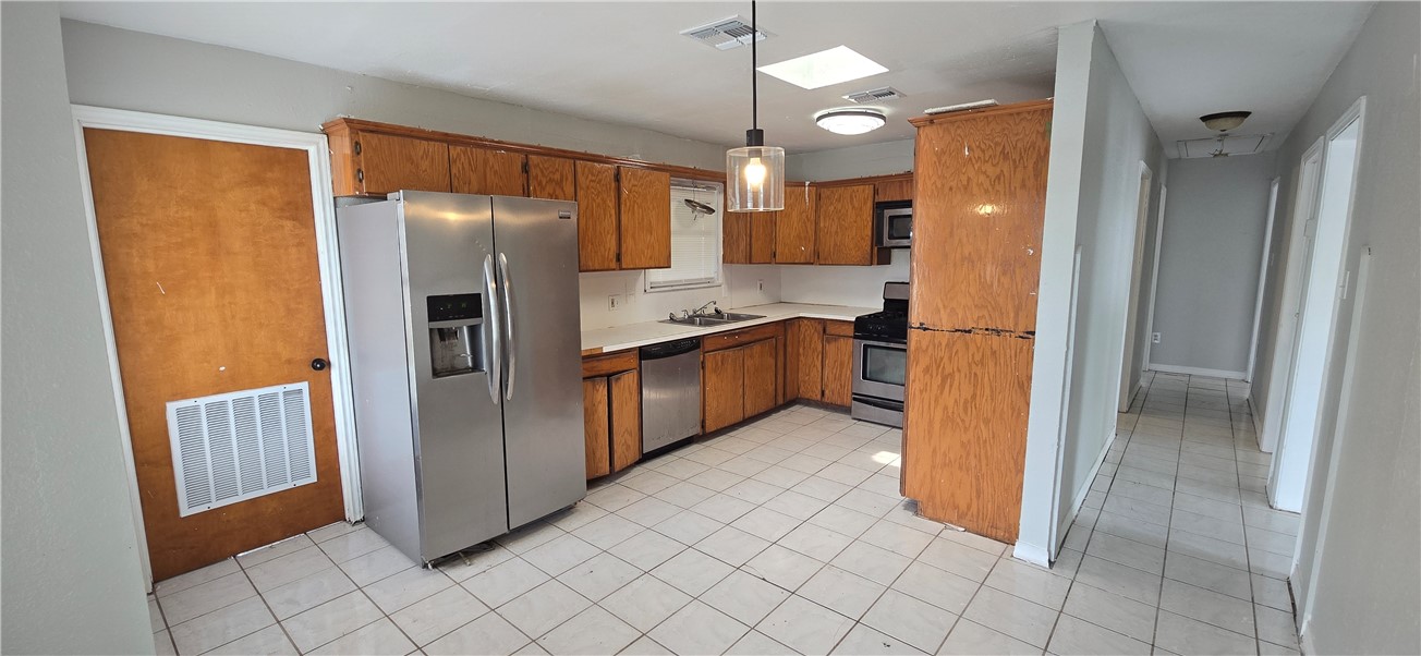 1013 Evergreen Street Mathis, TX 78368 - Photo 8 of 10 a kitchen with stainless steel appliances granite countertop a refrigerator and a sink