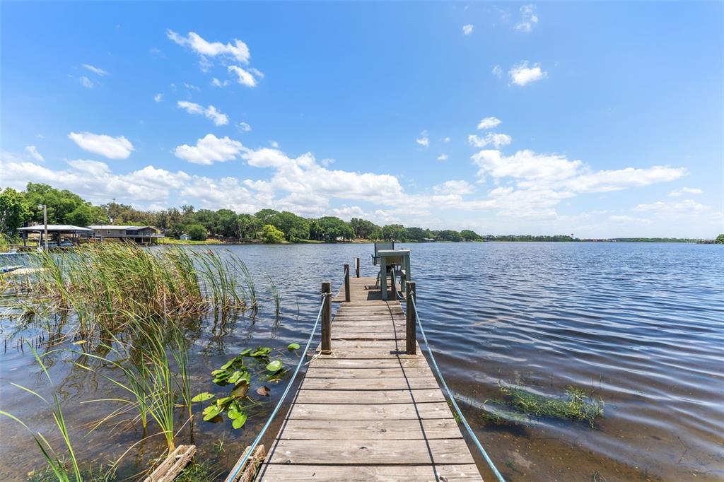 7570 Berkley Road Polk City, FL 33868 - Photo 1 of 16 a view of a lake with sitting area and roof