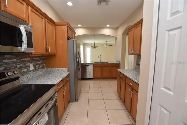 a kitchen with stainless steel appliances granite countertop a stove a sink and a microwave