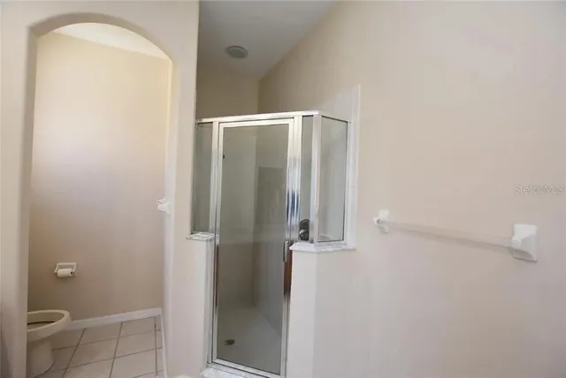 a bathroom with a granite countertop shower and a toilet
