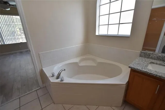 a white bath tub sitting in a bathroom next to a window