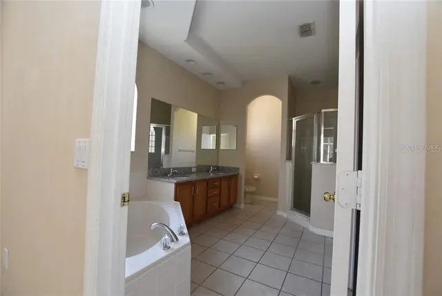 a bathroom with a granite countertop sink mirror and bathtub