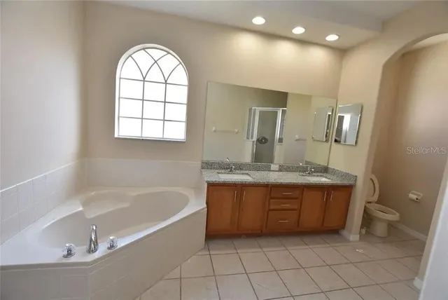 a bathroom with a granite countertop sink and a bathtub