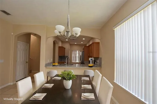 a view of a dining room and a livingroom with furniture wooden floor chandelier
