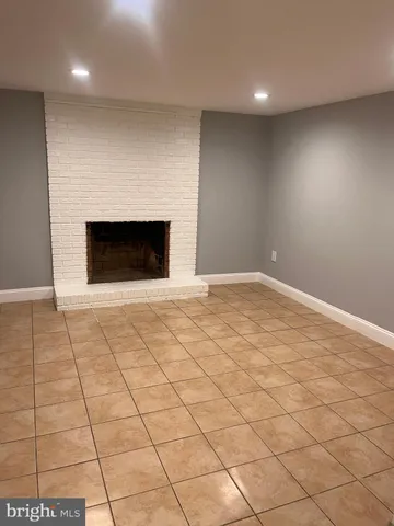 an empty room with windows and fireplace