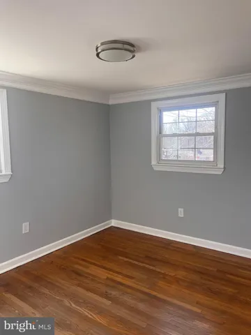 a view of a room with wooden floor and windows