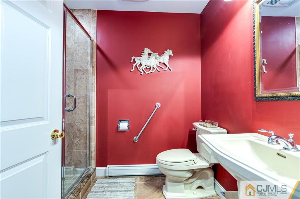 473 Plainfield Road Edison, NJ 08820 - Photo 12 of 28 a white toilet sitting next to a bathroom sink and vanity