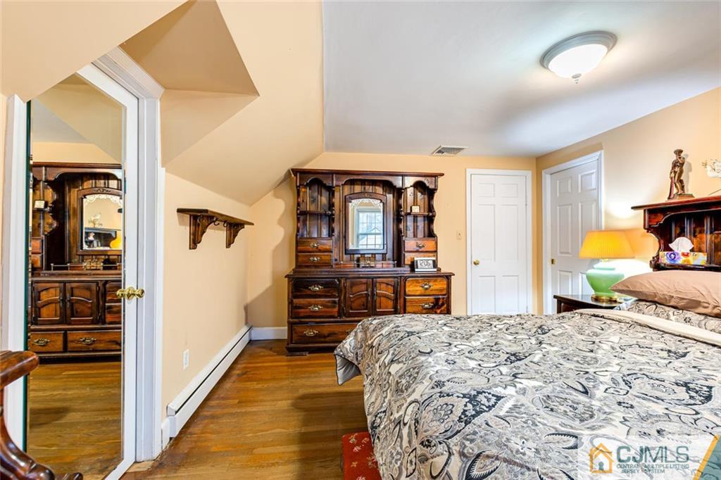 473 Plainfield Road Edison, NJ 08820 - Photo 21 of 28 a bedroom with a bed and dresser with mirror