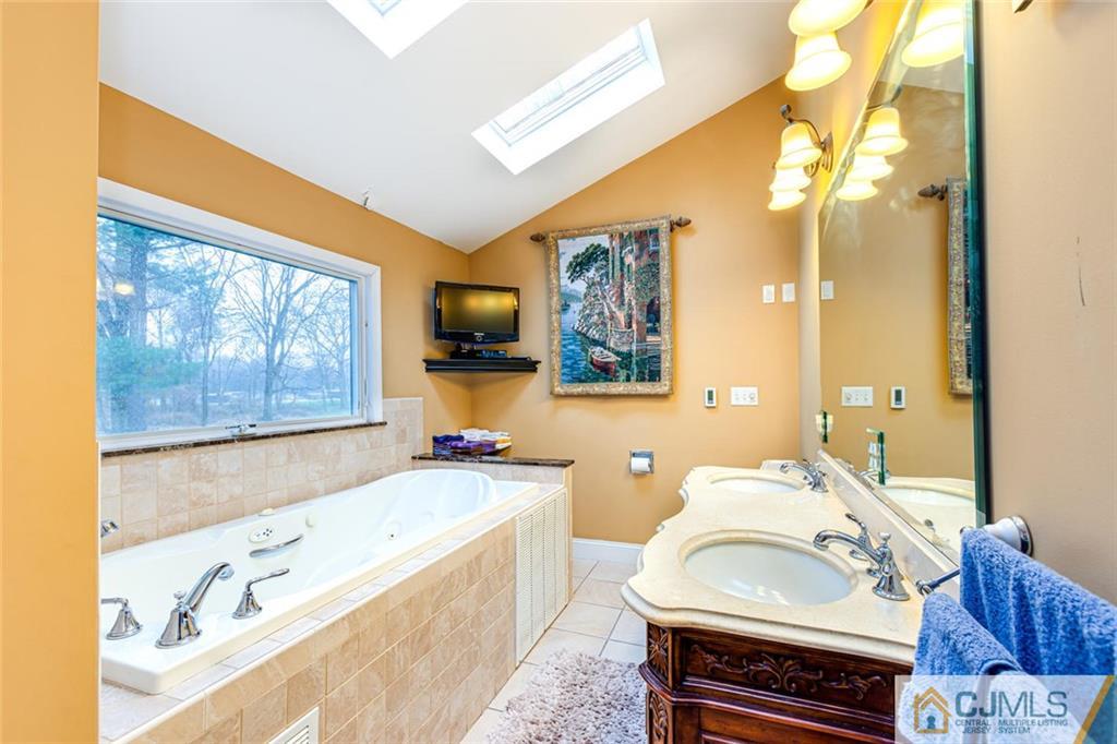 473 Plainfield Road Edison, NJ 08820 - Photo 22 of 28 a spacious bathroom with a sink a large mirror and a bathtub