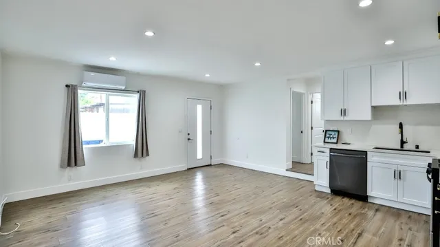 a view of kitchen with stainless steel appliances a refrigerator and wooden floor