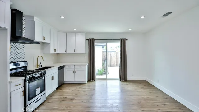 a kitchen with granite countertop a stove top oven sink and cabinets