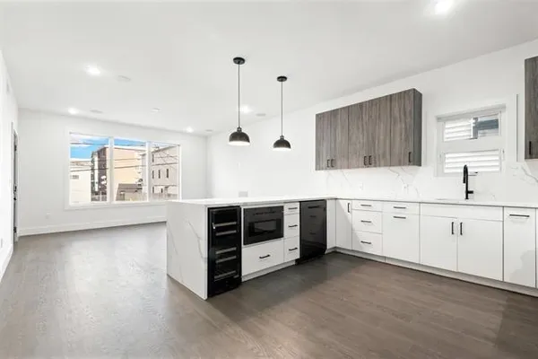 a kitchen with stainless steel appliances a stove top oven a sink a refrigerator and a window