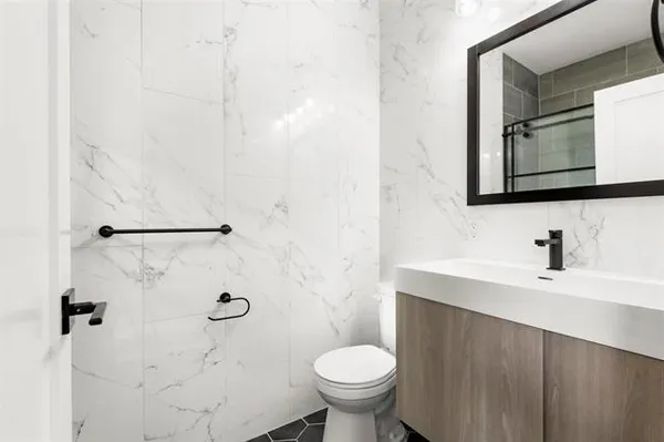 a bathroom with a sink toilet and a mirror