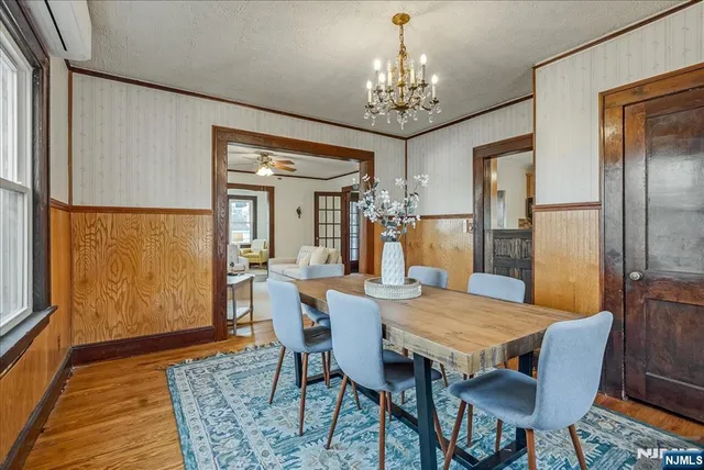 a view of a dining room with furniture a chandelier and wooden floor