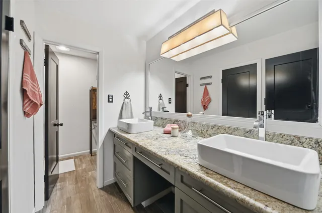 a en suite bathroom with a granite countertop sink and a mirror
