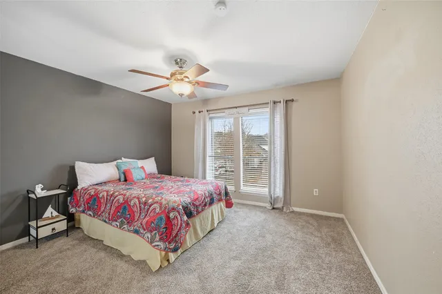 a bedroom with a bed and a chandelier fan