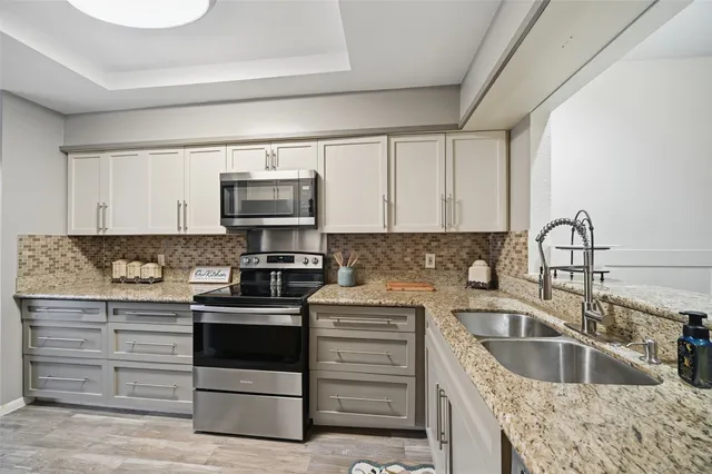 a kitchen with stainless steel appliances granite countertop a refrigerator and a stove