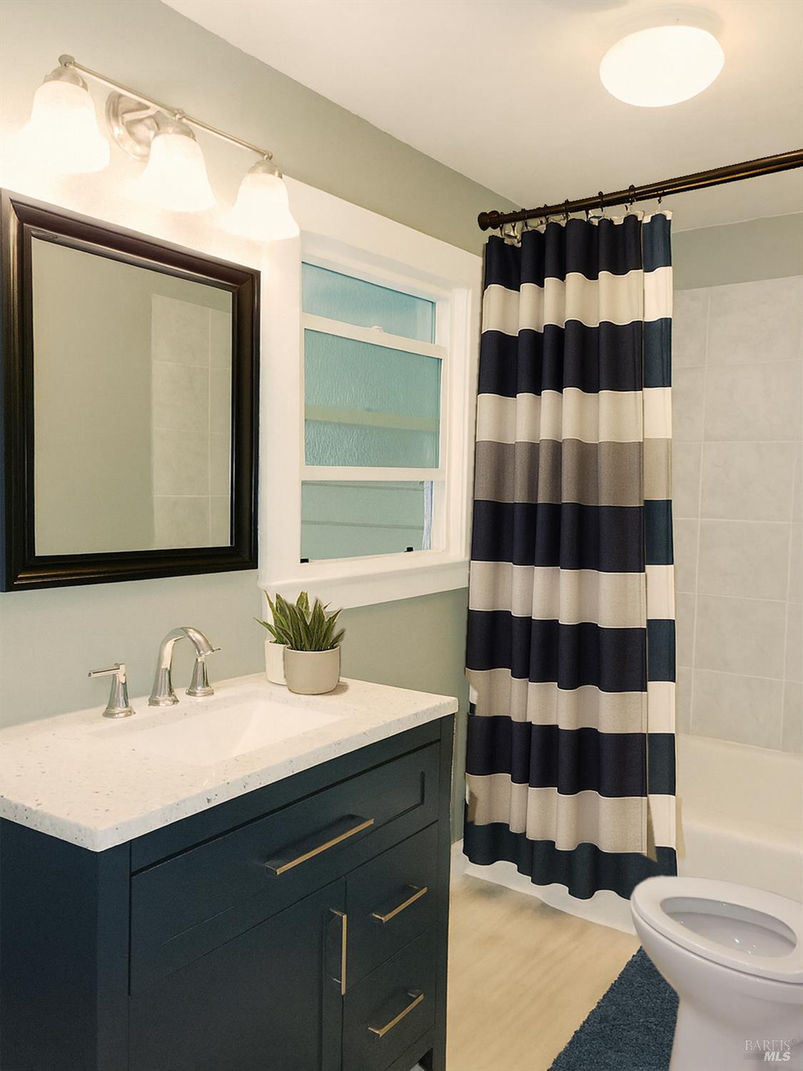 829 Hunt Avenue, Unit A St. Helena, CA 94574 - Photo 7 of 13 a bathroom with a sink a toilet a mirror and shower curtain
