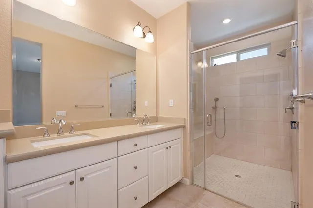 a bathroom with a shower sink and mirror