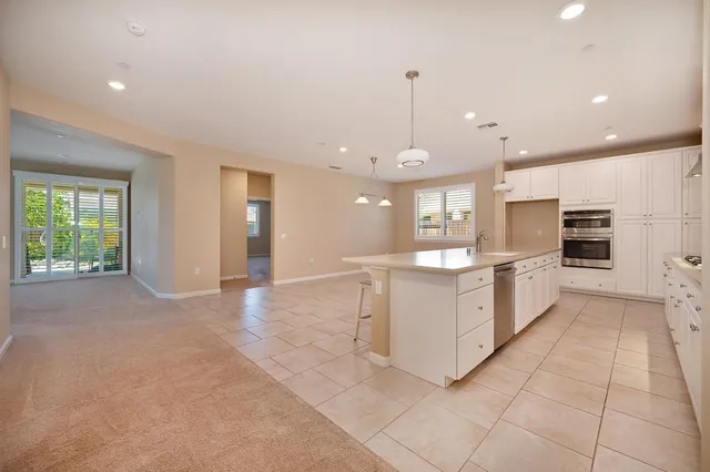 a large kitchen with a large counter top stainless steel appliances and cabinets