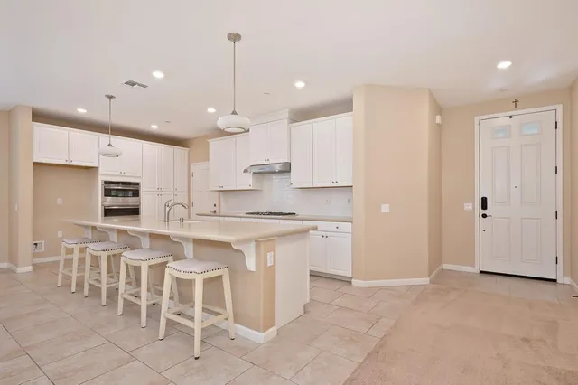 a large kitchen with cabinets chairs and view kitchen
