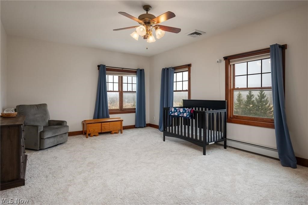 9419 Robinson Road Chardon, OH 44024 - Photo 32 of 49 Spacious room featuring light-toned carpeting, two windows with wood trim, and a ceiling fan with integrated lighting