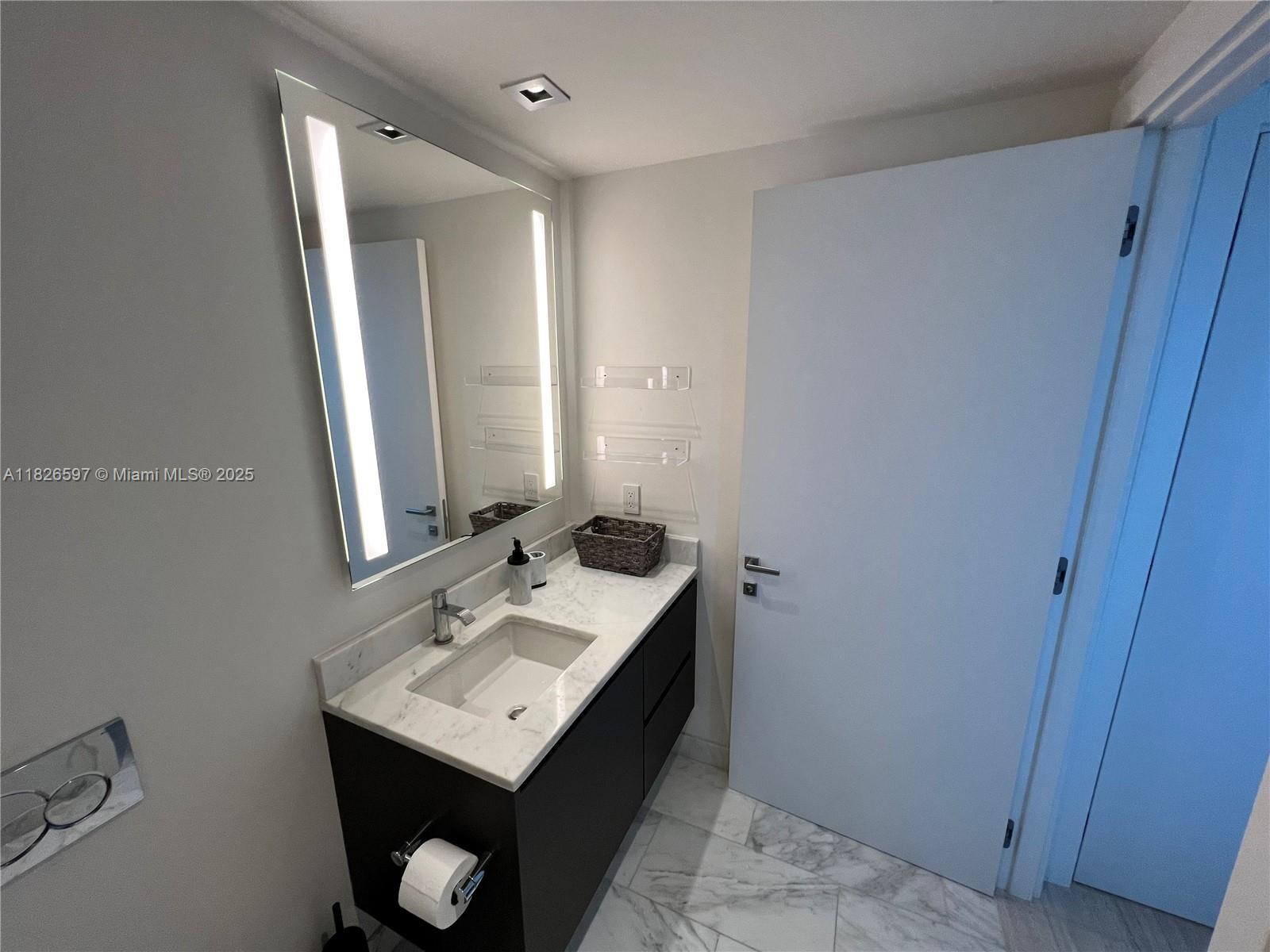 Brickell Miami, FL 33131 - Photo 17 of 23 a bathroom with a sink toilet and mirror