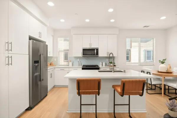 a kitchen with stainless steel appliances a stove a refrigerator and a dining table