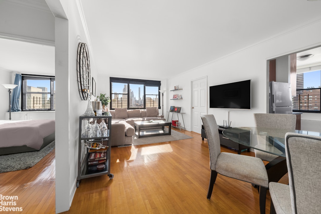 301 East 87th Street, Unit 25D Manhattan, NY 10128 - Photo 2 of 10 a living room with furniture and a flat screen tv