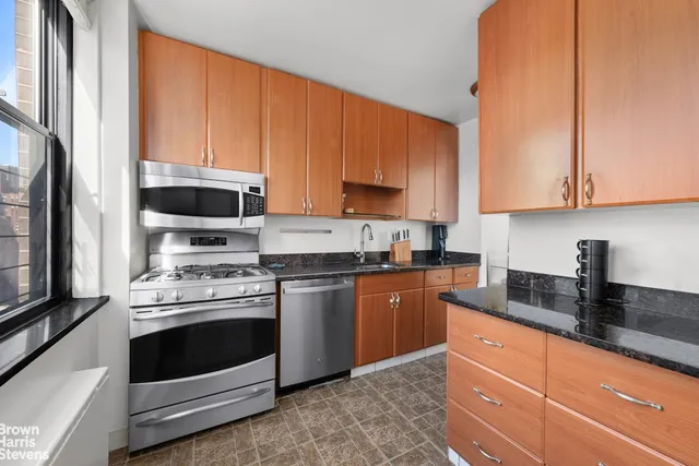 a kitchen with granite countertop a sink a stove and cabinets