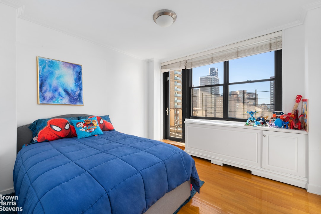 301 East 87th Street, Unit 25D Manhattan, NY 10128 - Photo 6 of 10 a bedroom with a bed and a large window