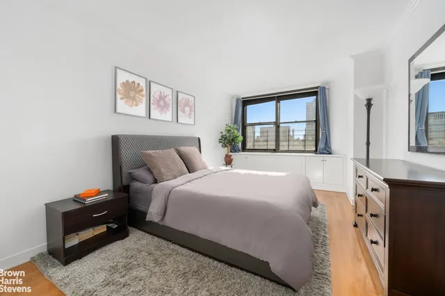 a bedroom with a bed and a large window