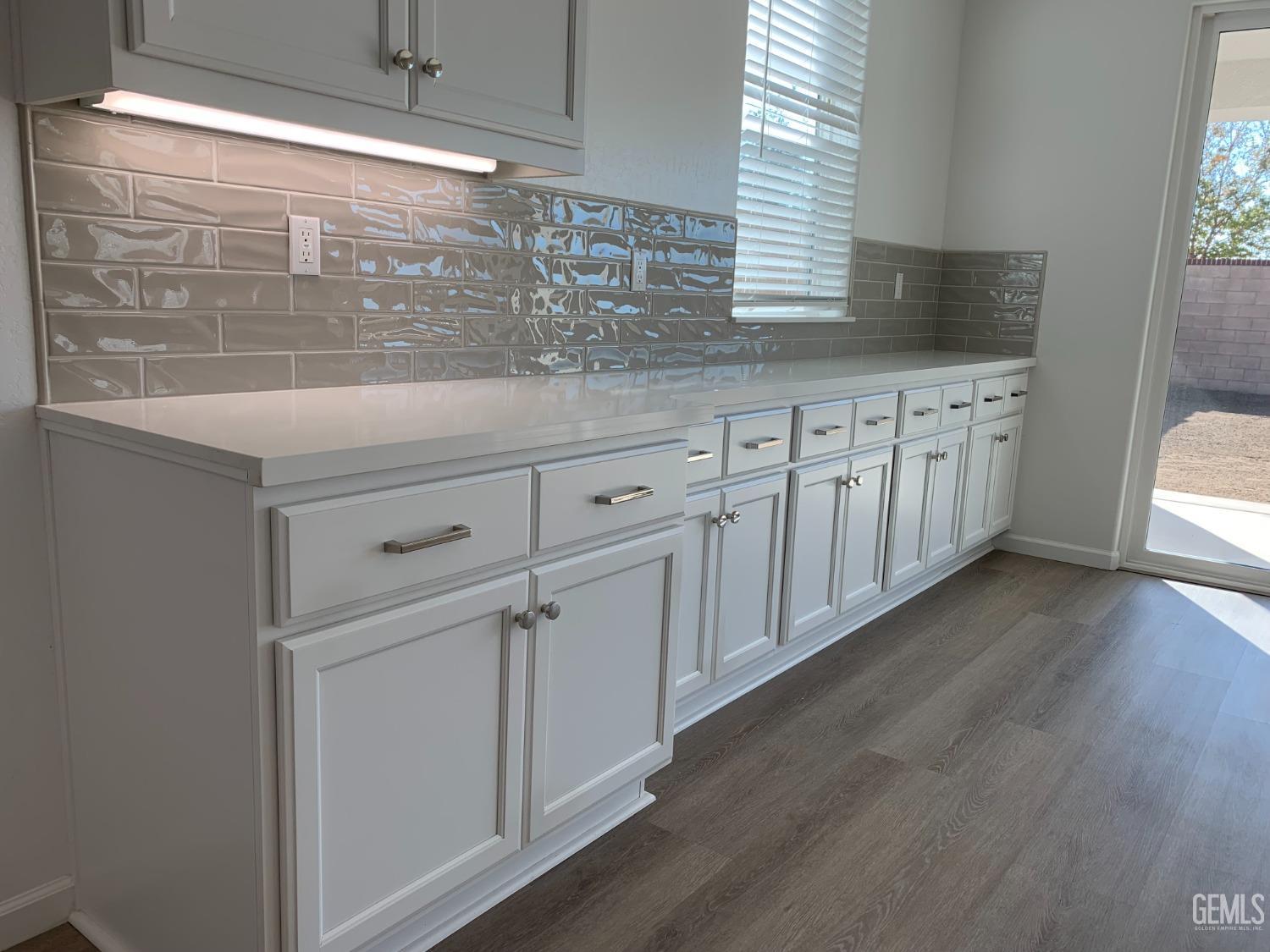 Undisclosed Address Bakersfield, CA 93314 - Photo 4 of 14 a kitchen with stainless steel appliances white cabinets and a wooden floor