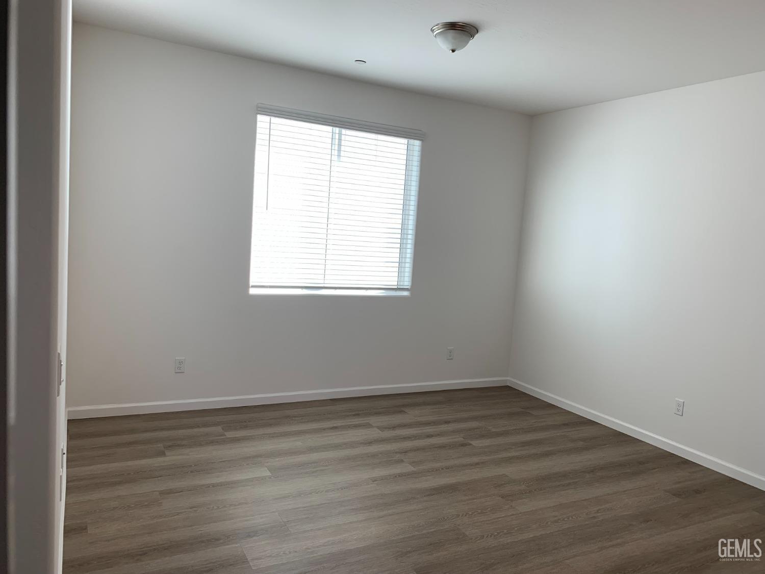 Undisclosed Address Bakersfield, CA 93314 - Photo 7 of 14 an empty room with wooden floor and windows