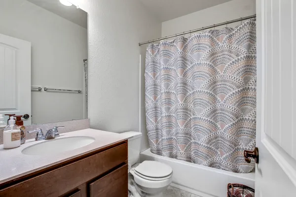 a bathroom with a granite countertop sink a toilet and a mirror