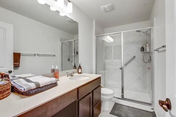a bathroom with a double vanity sink toilet and shower
