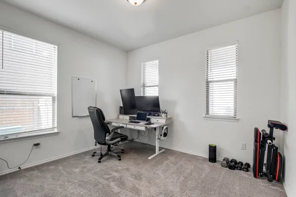 a view of a workspace with furniture and a window